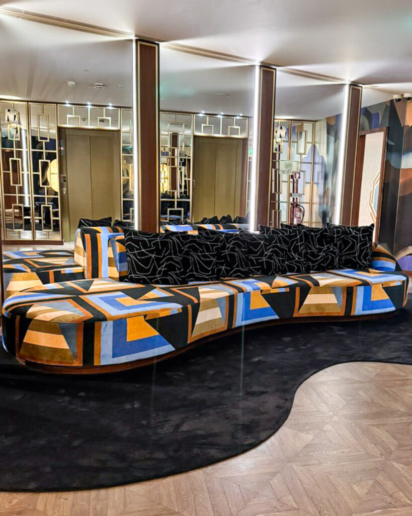 Tall wood-paneled library wall with grid shelving and contemporary sculptural chandelier
