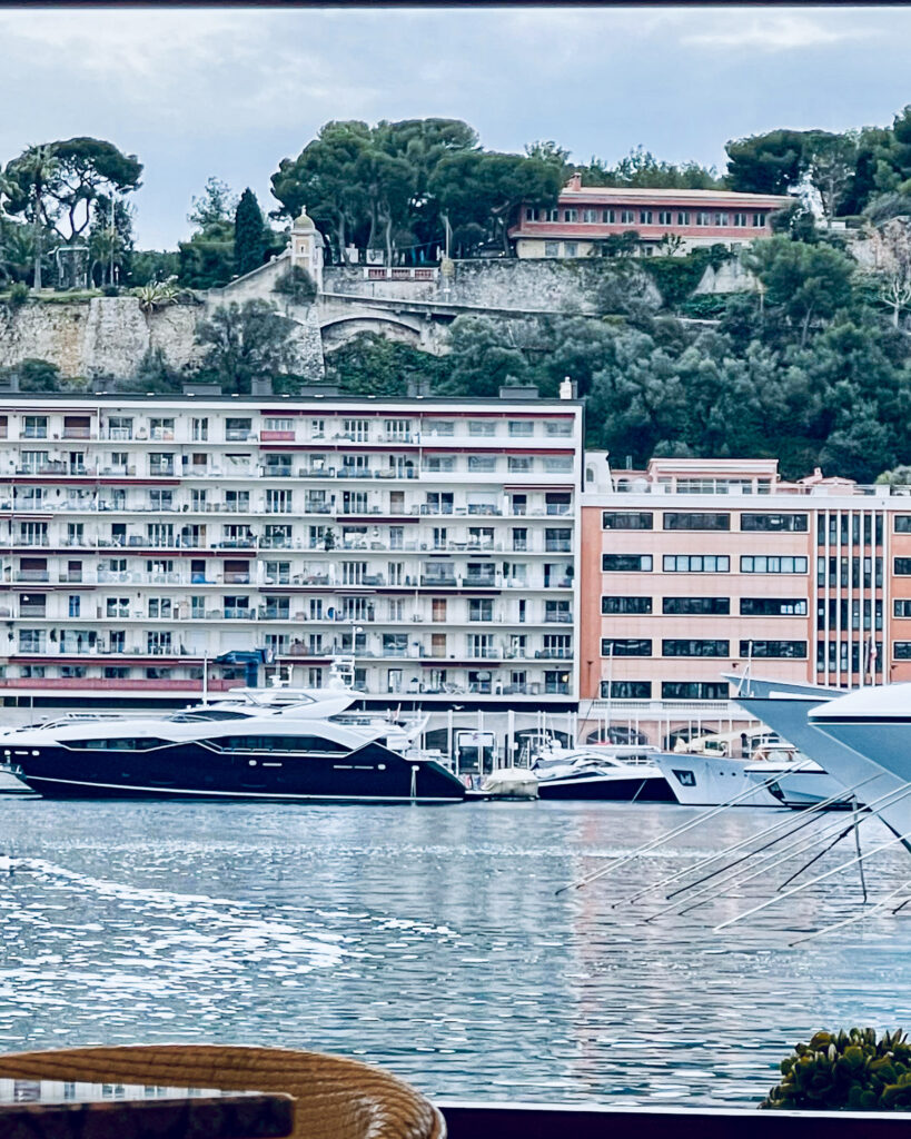 Deck view of yachts and pink buildings with mountain behind
