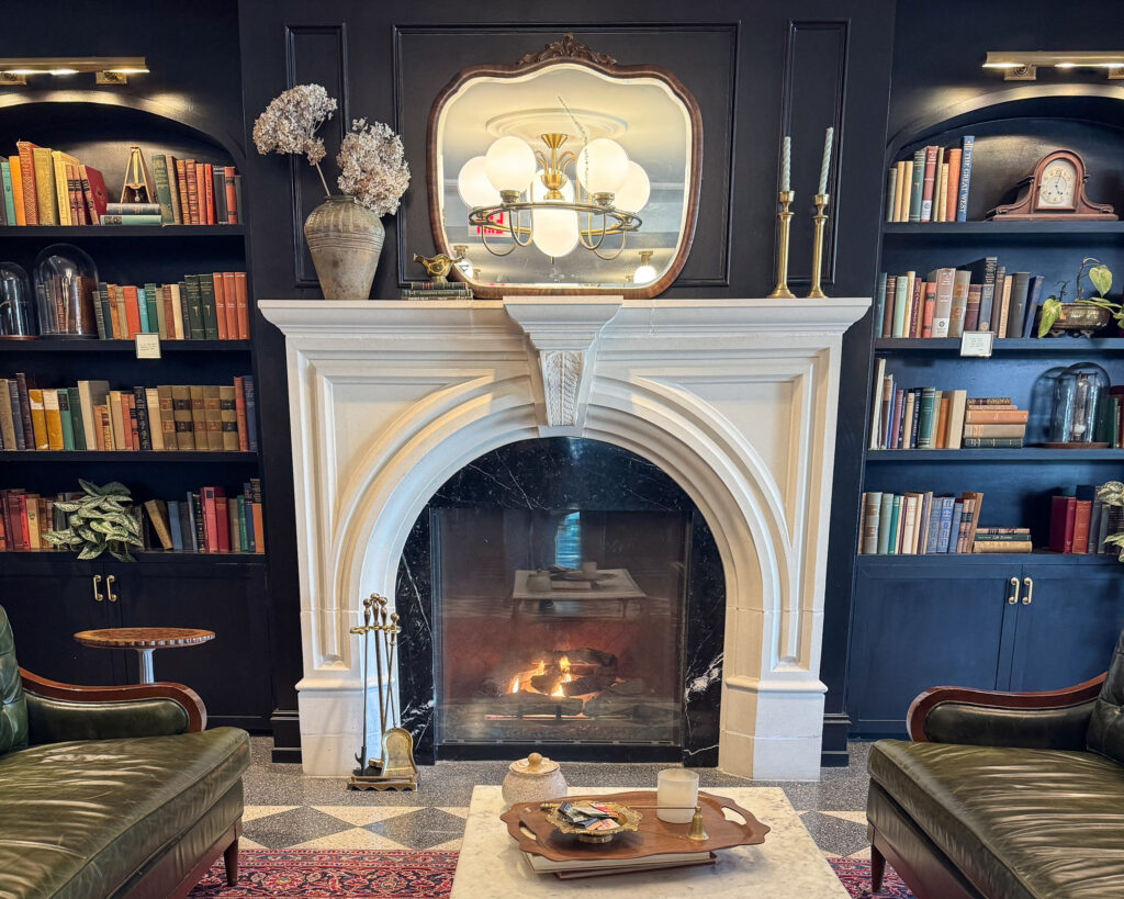Green leather sofas in a library lounge with cast stone fireplace